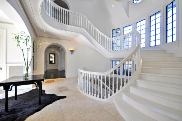white painted wooden half wall stair railing attached to the curved staircase