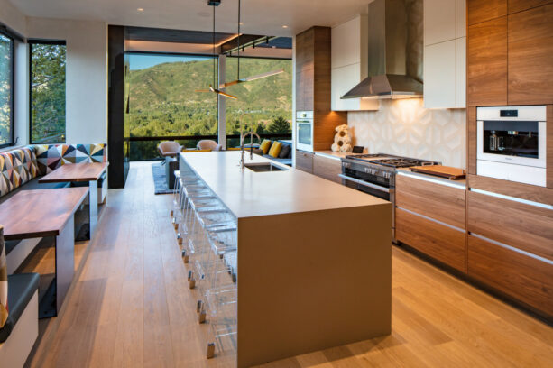 wood galley kitchen with clear stools at the breakfast bar
